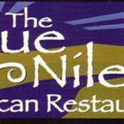 The Blue Nile logo,  two green palm trees against yellow sand dunes with a blue river running through them under a blue sky with a silhouette of a camel in the bottom corner, text reads "The Blue Nile East African Restaurant"